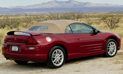 Convertible sports coupe with soft roof, rear spoiler, and alloy wheels