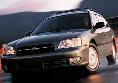 Front view of a station wagon on a wet road with headlights on