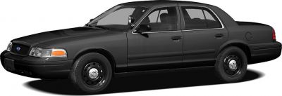 Black full-size sedan with police-style spotlight and steel wheels