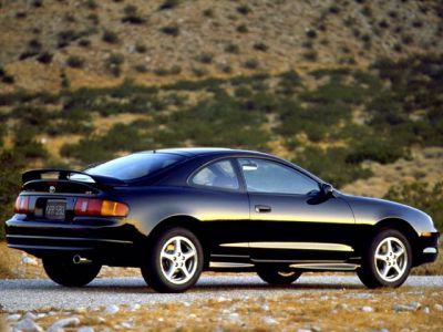 Black coupe with rear spoiler and alloy wheels in desert setting