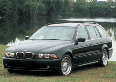Black station wagon with dual round headlights and roof rails