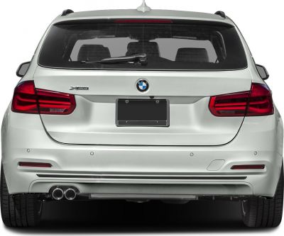 Rear view with xDrive badge and dual exhaust of a white station wagon