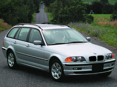 Silver station wagon with roof rails and alloy wheels on a road.