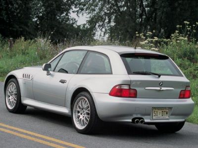 Silver car rear side view with distinctive hatchback and dual exhaust