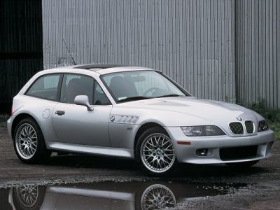 Side profile of a silver coupe with alloy wheels and distinctive vent details