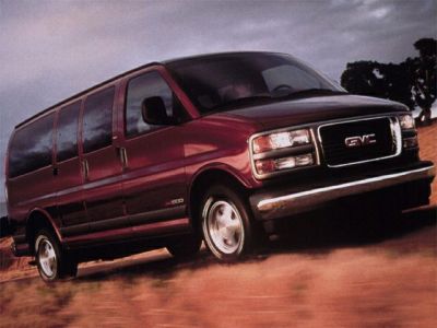Large full-size van in motion with sliding side doors and chrome bumper
