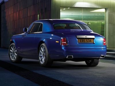 Blue luxury coupe rear view with dual exhaust and alloy wheels