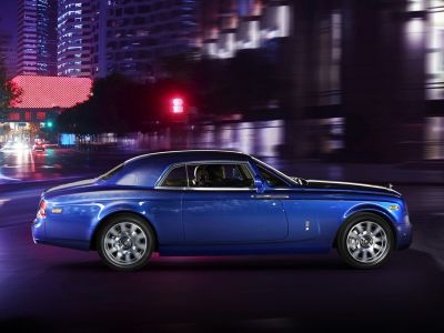 Luxury two-door coupe with alloy wheels and sleek roofline in urban nightscape