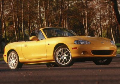 Yellow convertible with alloy wheels in a side profile view.
