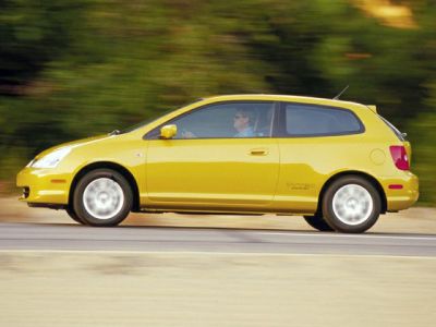 Side profile of a yellow three-door hatchback in motion