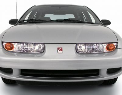 Close-up of dual headlights, front grill, and badge