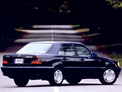 Rear side view of a black facelifted sedan with classic 1990s design.