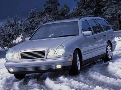 Silver estate car with dual round headlights parked on snow