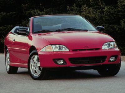 Red convertible front view with headlamps and alloy wheels