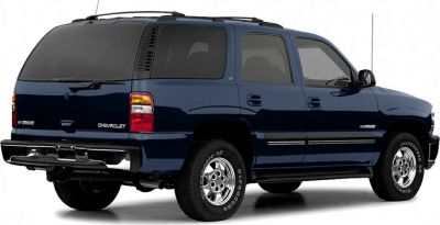 Rear side view of a dark blue 2000 SUV with rugged tires.