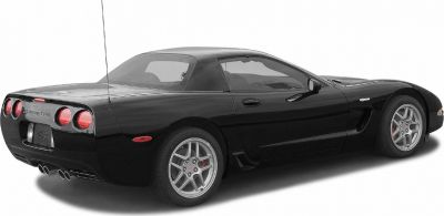 Rear and side view showing dual exhausts and round taillights on a black coupe.