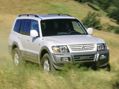 Front view of white SUV driving off-road with roof rails