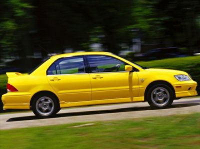 Bright yellow sedan with rear spoiler and alloy wheels in motion