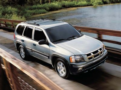 Silver SUV with tinted windows and roof rack on wooden bridge
