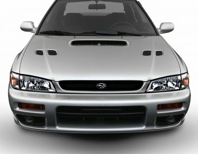 Front view with hood scoop, two hood vents, headlights, and fog lights.