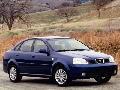 Front side view of a blue sedan with alloy wheels and distinct headlights.