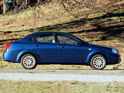 Side profile of a blue compact sedan with alloy wheels