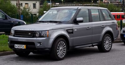 Front side view of gray SUV with distinctive grille and alloy wheels