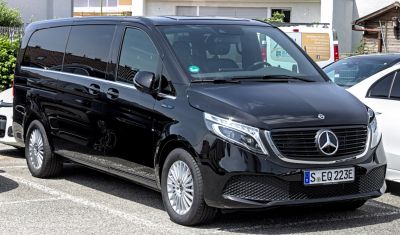 Front-side view of a black electric luxury van with smooth aerodynamic design and distinctive LED headlights