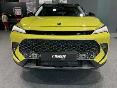 Wide mesh grille and sleek LED headlights on a yellow modern vehicle front.