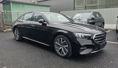 Luxury black sedan with wide grille and multi-spoke alloy wheels