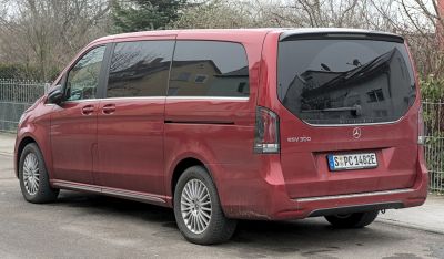 Rear side view of long luxury electric van with tinted windows and modern design