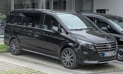 Front-side view of sleek black long van with alloy wheels and roof rails