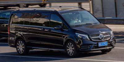 Front-side view of luxury black van with tinted windows and modern grille