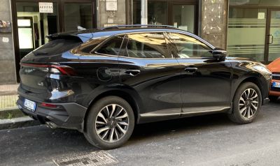 Black SUV side profile with rear view on urban street