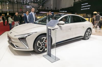 Front and side view of an electric sedan with futuristic headlights and modern wheels