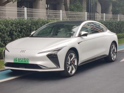 White electric sedan with angular LED headlights and multi-spoke alloy wheels