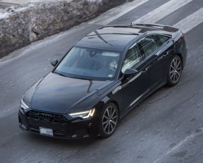 Front-side angle of a black sedan with LED headlights and honeycomb grille