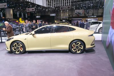 Sleek electric sedan side profile with distinct four-spoke wheels