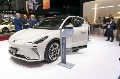 Front-side view of white electric sedan with open driver door