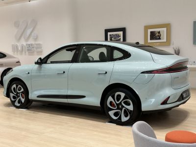 Side view of electric sedan with aerodynamic design and unique wheels