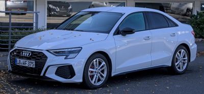 White sedan with sporty grille and alloy wheels front side view