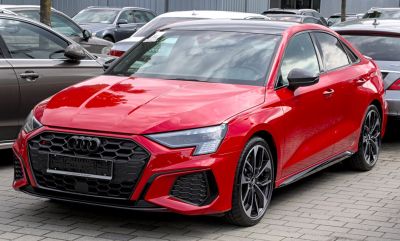 Sporty red sedan with honeycomb grille and sharp LED headlights