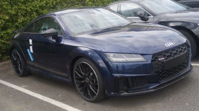 Front and side view of sporty coupe with LED headlights and aggressive grille