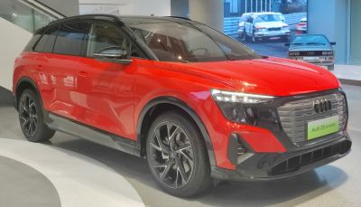Front angle view of red electric SUV with LED headlights and futuristic grille