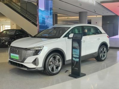 Front and side profile of a white electric SUV in a showroom