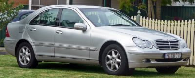 Silver sedan with dual round headlights and distinctive 5-spoke alloy wheels