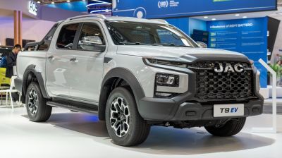 Front view close-up of electric double cab pickup with aggressive grille and modern LED headlights