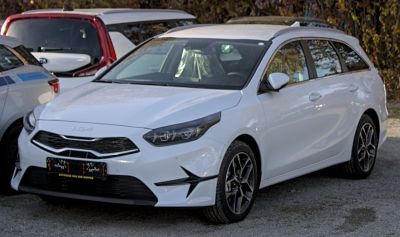 Front side view of a white station wagon with modern headlights and grille