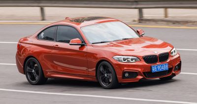 Red BMW 2 Series Coupe with modern headlights and sporty black wheels