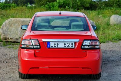 Rear view of red sedan with distinct taillights and trunk.